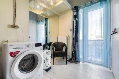 a washing machine in a room with a chair at Acropolis Penthouse with 50mbps WIFI in Athens