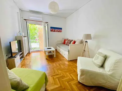 a living room with a couch and a table at Aegli of Acropolis - 50mbps wifi in Athens