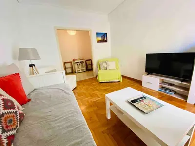 a living room with a couch and a tv at Aegli of Acropolis - 50mbps wifi in Athens