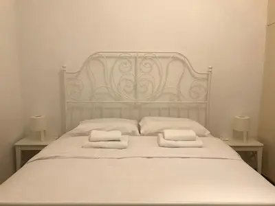 a white bed with two white towels on it at Aegli of Acropolis - 50mbps wifi in Athens