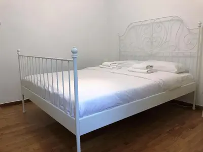 a white bed with white sheets and white pillows at Aegli of Acropolis - 50mbps wifi in Athens