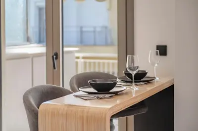 a wooden table with two chairs and two wine glasses at Lykavittos hill- penthouse in Athens
