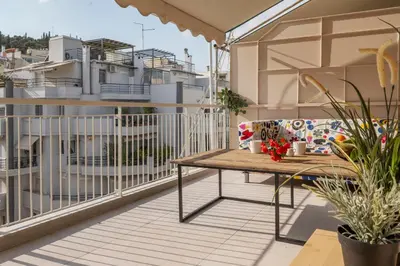 a balcony with a wooden table and a couch at Lykavittos hill- penthouse in Athens
