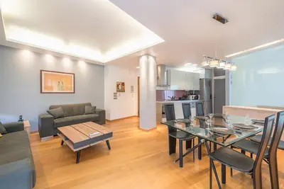 a living room with a dining room table and a kitchen at Agios Ioannis Metro station - Comfy Apartment in Athens