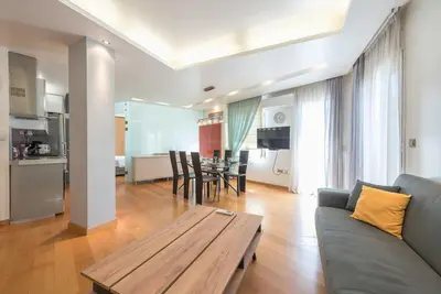 a living room with a couch and a wooden table at Agios Ioannis Metro station - Comfy Apartment in Athens