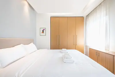 a bedroom with a large white bed and a window at Agios Ioannis Metro station - Comfy Apartment in Athens