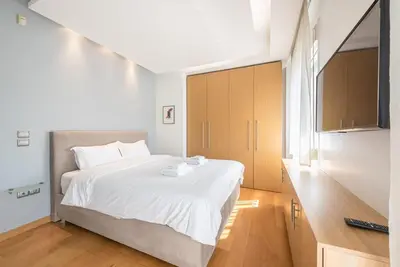 a bedroom with a large white bed and a window at Agios Ioannis Metro station - Comfy Apartment in Athens