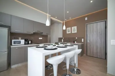 a kitchen with a large white island with stools at Athens city apartment B 100Mbps wifi in Athens