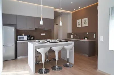 a kitchen with a white island with bar stools at Athens city apartment B 100Mbps wifi in Athens