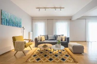 a living room with a blue couch and chairs at Luxury Athens Living 3BR with Balcony in Athens