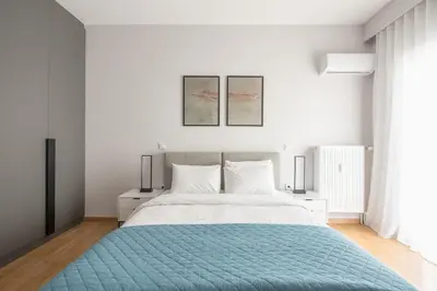 a bedroom with a large bed with a blue blanket at Luxury Athens Living 3BR with Balcony in Athens