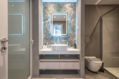 a bathroom with a sink and a mirror and a toilet at Luxury Athens Living 3BR with Balcony in Athens