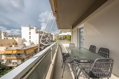 a balcony with a table and chairs on a balcony at Luxury Athens Living 3BR with Balcony in Athens