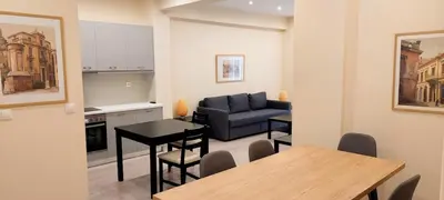 a kitchen and a living room with a table and a couch at Beautiful apartment in Acropolis in Athens