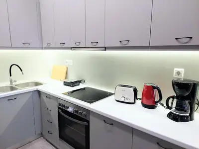 a kitchen with white cabinets and a counter top at Beautiful apartment in Acropolis in Athens