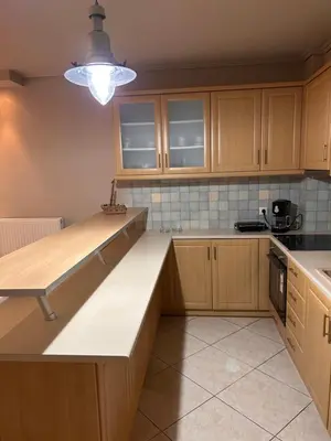 a kitchen with wooden cabinets and a counter top at Glyfada sunset Apartment in Athens