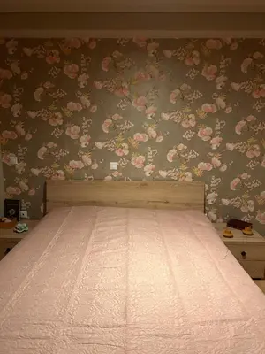 a bedroom with a bed with pink flowers on the wall at Glyfada sunset Apartment in Athens