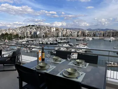 a table on a balcony with a view of a harbor at Stunning View Zeas Marina - 2 bedrooms in Piraeus