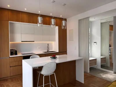 a kitchen with white countertops and wooden cabinets at Stunning View Zeas Marina - 2 bedrooms in Piraeus