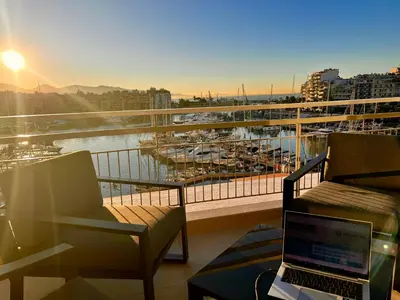 a balcony with a laptop computer sitting on a chair at Stunning View Zeas Marina - 2 bedrooms in Piraeus