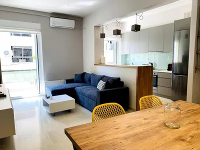 a living room with a blue couch and a table at Karyatis - Apartment on the road of history in Athens