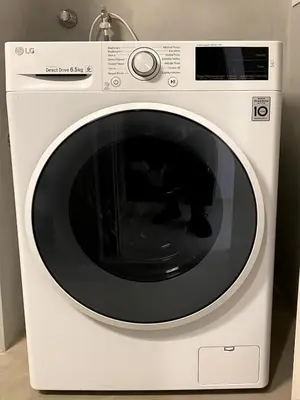 a white washing machine with a black window at Karyatis - Apartment on the road of history in Athens