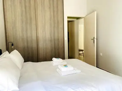 a white bed with towels on top of it at Karyatis - Apartment on the road of history in Athens