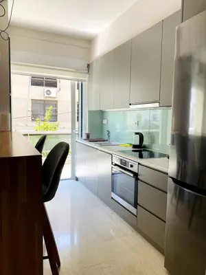 a kitchen with white cabinets and a stove top oven at Karyatis - Apartment on the road of history in Athens