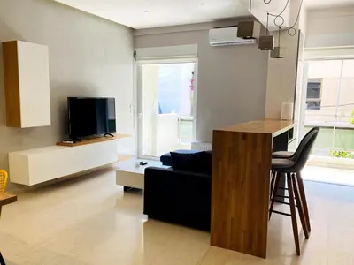 a living room with a couch and a tv at Karyatis - Apartment on the road of history in Athens