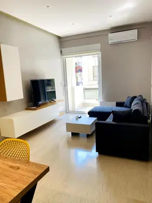 a living room with a couch and a tv at Karyatis - Apartment on the road of history in Athens
