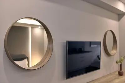 a mirror on a wall next to a tv at Live in Athens City center flat in Athens