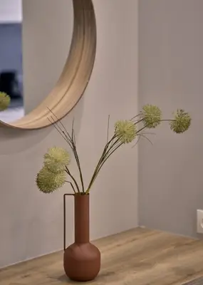 a vase with flowers sitting on a table in front of a mirror at Live in Athens City center flat in Athens