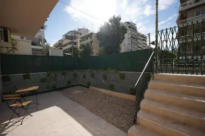 a patio with stairs and a fence and a table at Lovely Front Garden 2 BDRM Nea Smyrni in Athens