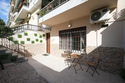 a patio with chairs and a table in front of a building at Lovely Front Garden 2 BDRM Nea Smyrni in Athens