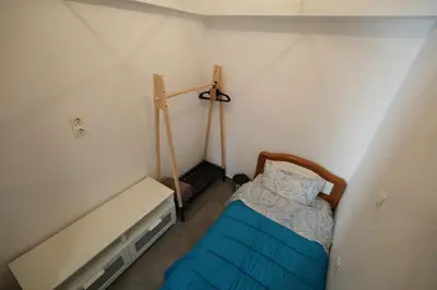 a small bedroom with a bed with a blue blanket at Lovely Front Garden 2 BDRM Nea Smyrni in Athens