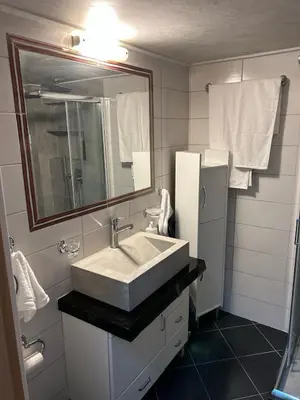 a bathroom with a sink and a mirror and a refrigerator at Κεντρικό διαμέρισμα στην Αθηνα in Athens