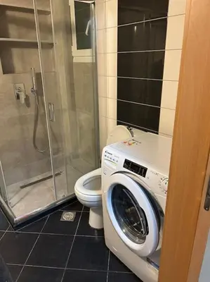 a bathroom with a washing machine and a toilet at Κεντρικό διαμέρισμα στην Αθηνα in Athens