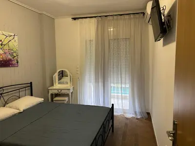 a bedroom with a bed and a large window at Κεντρικό διαμέρισμα στην Αθηνα in Athens