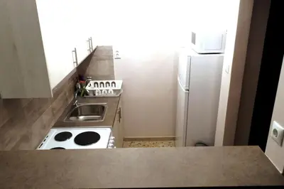 a small kitchen with a stove and a refrigerator at Near by Acropolis in Athens