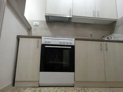 a kitchen with white cabinets and an oven at Near by Acropolis in Athens