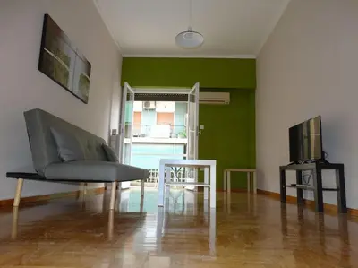 a living room with a couch and a table and a tv at Near by Acropolis in Athens