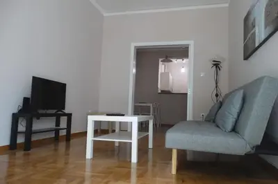 a living room with a couch and a table and a television at Near by Acropolis in Athens