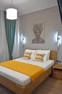 a bedroom with a large bed with yellow blanket at Maya Studio Piraeus in Piraeus