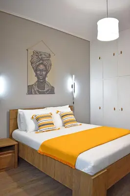 a bedroom with a large bed with orange blanket at Maya Studio Piraeus in Piraeus