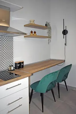 a kitchen with a desk and a green chair at Maya Studio Piraeus in Piraeus
