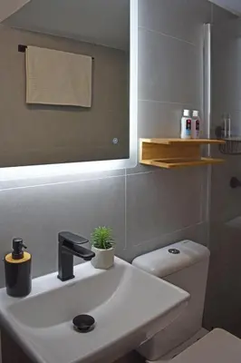 a bathroom with a sink and a toilet and a mirror at Maya Studio Piraeus in Piraeus