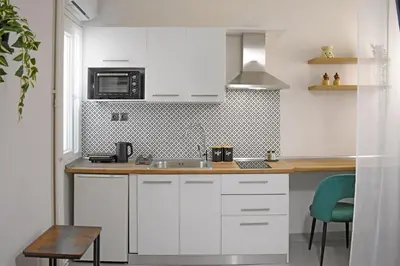 a white kitchen with a sink and a microwave at Maya Studio Piraeus in Piraeus