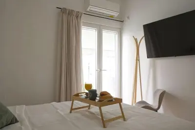 a bedroom with a bed with a table and a window at Vibrant 2BR in Koukaki in Athens