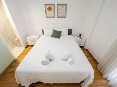 a bedroom with a large white bed with two pillows at Vibrant 2BR in Koukaki in Athens