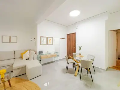 a living room with a couch and a table at Vibrant 2BR in Koukaki in Athens